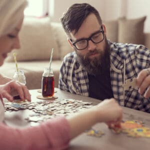 A man and woman are playing a puzzle.