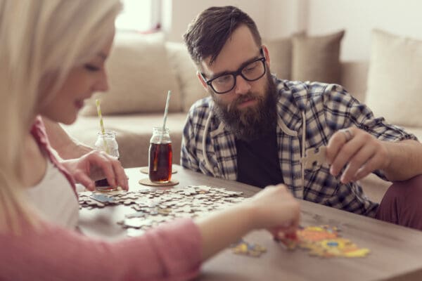 A man and woman are playing a puzzle.