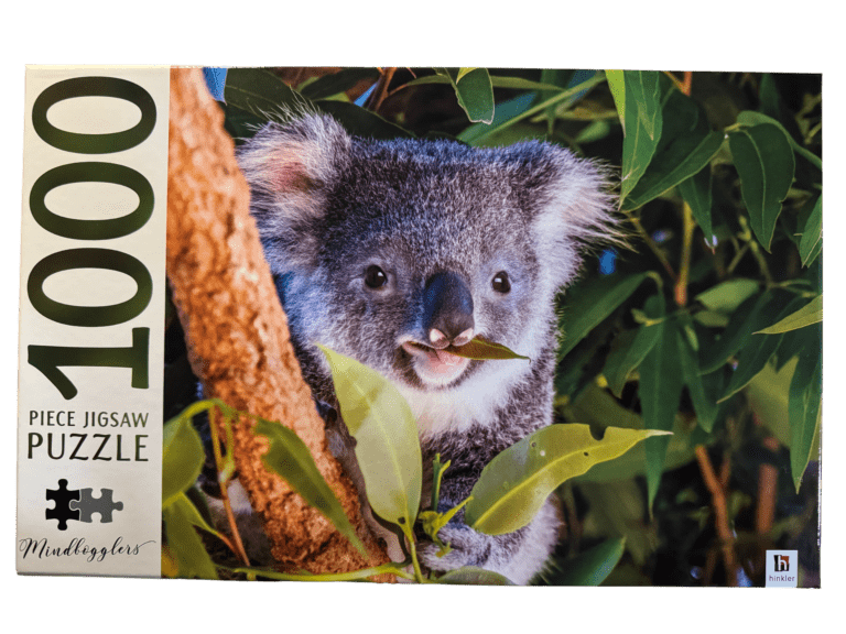 A koala bear is eating leaves off of a tree.